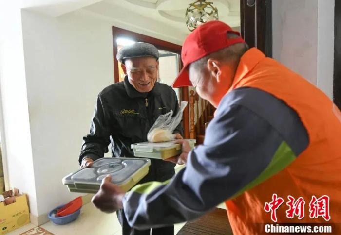 志愿者为老人送爱心餐。王刚 摄 志愿者为老人送爱心餐。王刚 摄