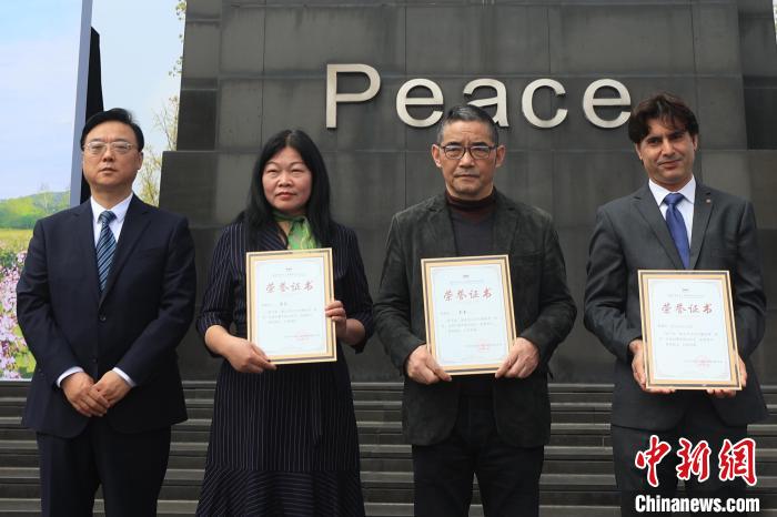 纪念馆馆长为紫金草文化传播使者授牌。 泱波 摄 纪念馆馆长为紫金草文化传播使者授牌。 泱波 摄